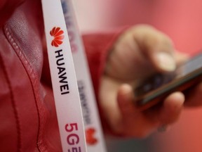 An attendee wears a badge strip with the logo of Huawei and a sign for 5G at the World 5G Exhibition in Beijing, China November 22, 2019.