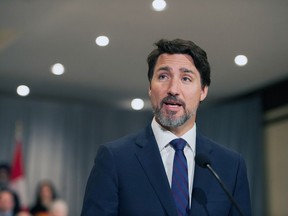 Prime Minister Justin Trudeau stands in front of his cabinet as he speaks to media during the final day of the Liberal cabinet retreat at the Fairmont Hotel in Winnipeg, Tuesday, Jan. 21, 2020.