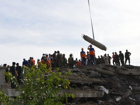 Rescue personnel work at the site where an under-construction building on Friday collapsed, trapping and killing workers, in southern Cambodia's coastal Kep province on Saturday, Jan. 4, 2020.