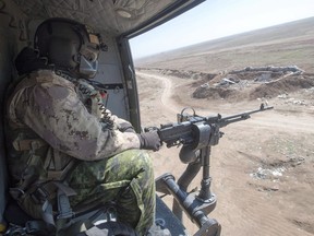A Canadian Forces door gunner keeps watch as his Griffon helicopter goes on a mission, Feb. 20, 2017 in northern Iraq.