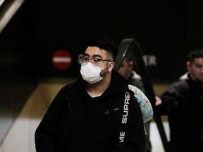 A traveler wearing a mask arrives on a direct flight from China, after a spokesman from the U.S. Centers for Disease Control and Prevention (CDC) said a traveler from China had been the first person in the United States to be diagnosed with the Wuhan coronavirus, at Seattle-Tacoma International Airport in Washington, U.S. January 23, 2020.