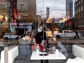 A server attends to customers at a restaurant in the Chinatown district of downtown Toronto, after three patients with novel coronavirus were reported in Canada Jan. 28, 2020.