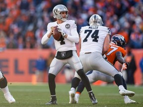 Raiders quarterback Derek Carr (4) looks to pass as offensive tackle Kolton Miller (74) defends against Broncos linebacker Jeremiah Attaochu (97) during NFL acton at Empower Field at Mile High in Denver, on Dec. 29, 2019.