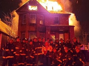 A now-deleted image of a group of Detroit firefighters posing in front of a burning house in Detroit was posted on Detroit Fire Incidents Page on Facebook on New Year's Eve.