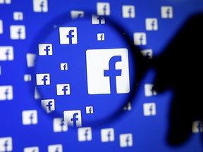 A man poses with a magnifier in front of a Facebook logo on display in this illustration taken in Sarajevo, Bosnia and Herzegovina, December 16, 2015. (REUTERS/Dado Ruvic/Illustration/File Photo)