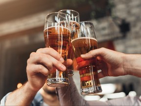 Friends toasting with glasses of beer at the pub