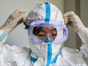 This file photo taken on Jan. 30, 2020 shows a doctor putting on a pair of protective glasses before entering the isolation ward at a hospital in Wuhan in China's central Hubei province, during the virus outbreak in the city. (STR/AFP via Getty Images)