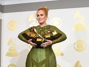Adele poses in the press room with her trophies, including the top two Grammys of Album and Record of the Year for her blockbuster hit "Hello" and the album "25", during the 59th Annual Grammy music Awards on February 12, 2017,