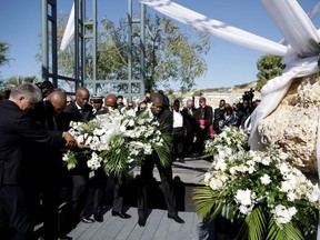 Haiti's President Jovenel Moise and foreign representatives carry a bouquet of flowers during a ceremony at a memorial for the tenth anniversary of the January 12, 2010 earthquake, in Titanyen, Haiti, January 12, 2020.