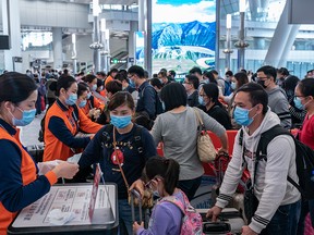 Travellers wearing face mask wait in line at the departure hall of West Kowloon Station on Jan. 23, 2020 in Hong Kong.