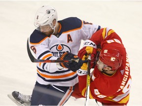 Oilers Adam Larsson (L) and Flames Andrew Mangiapane collide at centre ice during NHL action between the Edmonton Oilers and the Calgary Flames in Calgary on Saturday, January 11, 2020. Jim Wells/Postmedia