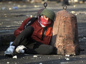 An Iraqi protester takes cover amid clashes with riot police following a demonstration at Baghdad's Tayaran Square, east of Tahrir Square, on January 20, 2020. (AHMAD AL-RUBAYE/AFP via Getty Images)