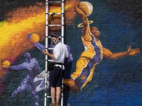 Artist Kiptoe helps paint a mural as a memorial to NBA legend Kobe Bryant, who was killed last weekend in a helicopter accident, in West Hollywood on January 30, 2020. (MARK RALSTON/AFP via Getty Images)