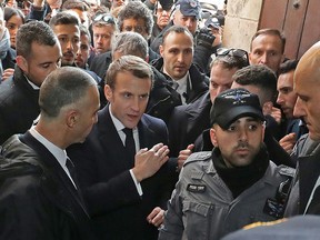 French President Emmanuel Macron (top) asks Israeli police to leave the 12th-century Church of Saint Anne in the old city of Jerusalem on January 22, 2020. (LUDOVIC MARIN/AFP via Getty Images)