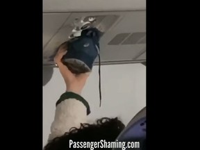 In a video shared by is seen shoving the Instagram account Passenger Shaming, a sneaker into the overhead vent, persumably to dry it. (Passenger Shaming/Instagram)