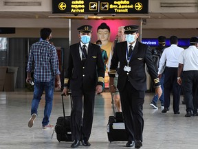 Pilots wearing protective facemasks walk at Bandaranaike International airport in Katunayake on January 30, 2020. (LAKRUWAN WANNIARACHCHI/AFP via Getty Images)