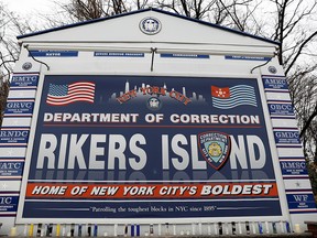 Candles are seen on the sign marking the entrance to the New York City Department of Corrections Rikers Island facility in New York February 14, 2018. (REUTERS/Shannon Stapleton/File Photo)
