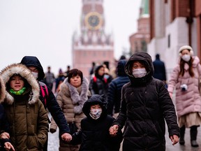 In this file photo taken on Jan. 29, 2020, Tourists wearing facemasks walk on Red Square in downtown Moscow.