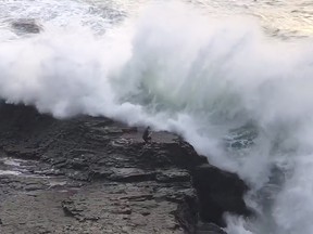 A man is seen standing on rocks near Bonny Doon Beach in Bonny Doon, Calif.