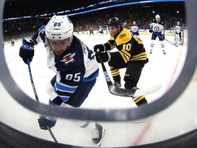 Anders Bjork of the Boston Bruins defends Mathieu Perreault of the Winnipeg Jets during the first period at TD Garden on Jan. 9, 2020 in Boston.