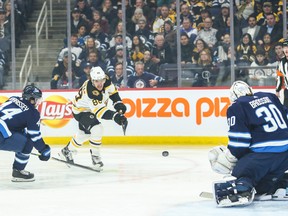 Boston Bruins forward David Pastrnak takes a shot against Winnipeg Jets goalie Laurent Brossoit during Friday's game. (USA TODAY SPORTS)