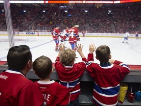 David St-Germain with his two sons — 2-year-old Emile and 4-year-old Liam — and 4-year-old Louis Samson watch as the Canadiens take part in their annual skills competition at the Bell Centre in Montreal on Sunday, Feb. 9, 2020.