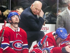Montreal Canadiens head coach Claude Julien stares at the floor after the Arizona Coyotes scored the winning goal with one minute to play in the game in Montreal on Feb. 10, 2020. Tomas Tatar, left, and Brendan Gallagher sit in front of him.