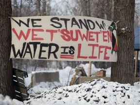 Natives fly a Water is Life banner at the check point as the Mohawks of Kahnawake continue their blockade of the CP Rail lines south of Montreal on Friday, Feb. 28, 2020.