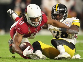 Wide receiver Larry Fitzgerald of the Arizona Cardinals makes a reception ahead of cornerback Mike Hilton of the Pittsburgh Steelers during the first half of the NFL game at State Farm Stadium on December 08, 2019 in Glendale, Arizona.