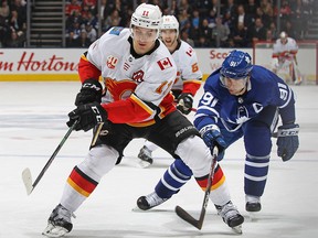Mikael Backlund of the Calgary Flames skates against a checking John Tavares of the Toronto Maple Leafs during an NHL game at Scotiabank Arena on Jan. 16, 2020, in Toronto.