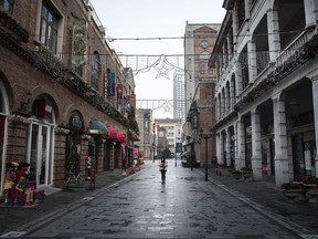 A woman wears a protective mask walks down an empty street on February 3, 2020 in Wuhan, Hubei province, China.