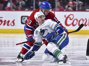 Canadiens's Max Domi takes down Canucks' Jay Beagle during second period Tuesday night at the Bell Centre.