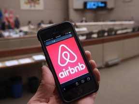 The logo for Airbnb is seen on a smartphone.