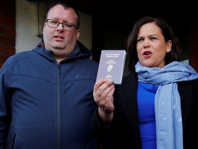 Sinn Fein leader Mary Lou McDonald shows her passport as she leaves the polling station after casting her vote in Ireland's national election, in Dublin, Ireland, Feb. 8, 2020. REUTERS/Phil Noble