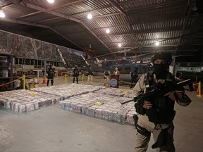 A police officer is seen in front of packages containing cocaine seized during an operation in the Caribbean, as Michael Soto, Minister of Public Security, speaks to the media at the air base of the Ministry of Security in Alajuela, Costa Rica, Feb. 15, 2020. REUTERS/Juan Carlos Ulate