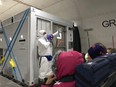 A U.S. health official in a protective suit standing in front of a portable bio-containment unit speaks to U.S. passengers who have chosen to leave the Diamond Princess cruise ship, on a chartered evacuation aircraft to fly back to the United States, at Haneda airport in Japan Feb. 17, 2020. (Courtesy of Philip and Gay Courter/via REUTERS)