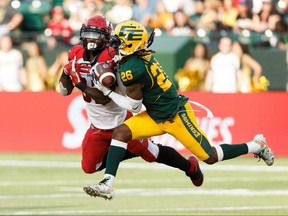 Edmonton Eskimos' Josh Johnson (26) catches an interception on Calgary Stampeders' Josh Huff (83) during the first half of CFL football action at Commonwealth Stadium in Edmonton, on Saturday, Sept. 7, 2019. Photo by Ian Kucerak/Postmedia