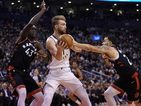 Pacers forward Domantas Sabonis is double-teamed by Pascal Siakam (left) and Fred VanVleet of the Raptors Wednesday night at Scotiabank Arena.