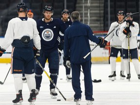 Edmonton Oilers' head coach Dave Tippett (with stick) speaks with his players during a practice on the ice at Rogers Place in Edmonton, on Friday, Feb. 7, 2020. The team plays the Nashville Predators on Saturday.