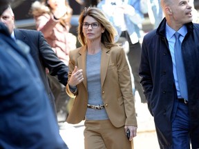 In this file photo taken on April 03, 2019 Actress Lori Loughlin (C) arrives at the court to appear before Judge M. Page Kelley to face charge for allegedly conspiring to commit mail fraud and other charges in the college admissions scandal at the John Joseph Moakley United States Courthouse in Boston, Massachusetts.