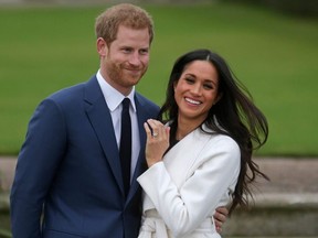 In this file photo taken on on November 27, 2017, Britain's Prince Harry stands with his fiancee US actress Meghan Markle as she shows off her engagement ring whilst they pose for a photograph in the Sunken Garden at Kensington Palace in west London, following the announcement of their engagement.