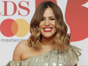 In this file photo taken on Feb. 21, 2018, British television presenter Caroline Flack poses on the red carpet on arrival for the BRIT Awards 2018 in London. (OLGA AKMEN/AFP via Getty Images)