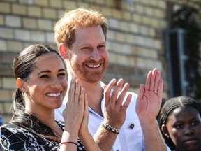 In this file photo taken on September 23, 2019 Prince Harry, Duke of Sussex and Meghan, Duchess of Sussex arrive to visit the "Justice desk", an NGO in the township of Nyanga in Cape Town, as they begin their tour of the region.