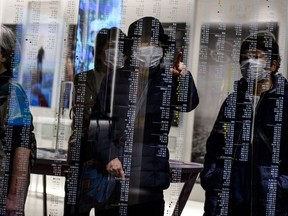 Visitors wearing face masks, amid concerns over the spread of the COVID-19 novel coronavirus, visit the Japan Olympic Museum in Tokyo on February 26, 2020.