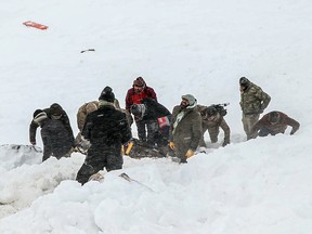 Security officers and villagers carry a victim of an avalanche near the town of Bahcesehir, in the eastern Turkey province of Van, on February 5, 2020 (DHA/DHA/AFP via Getty Images)