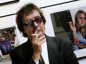 Former Rolling Stones bass player Bill Wyman stands in front of his photos in VIP's International Art Galleries in Rotterdam in 2006. (MAARTJE BLIJDENSTEIN/AFP/Getty Images)