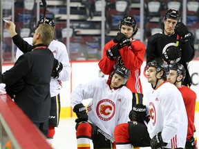 Calgary Flames players listen to drill instructions from head coach Geoff Ward during team practice in Calgary on Monday, Feb. 3, 2020.