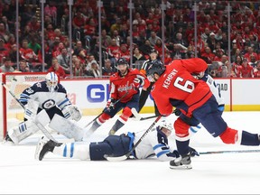 Capitals’ Michal Kempny shoots the puck as Jets’ Tucker Poolman blocks the path to netminder Laurent Brossoit during the first period of Tuesday night’s game at Capital One Arena in Washington. (USA TODAY SPORTS)