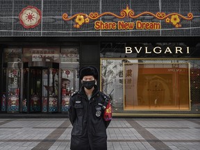 A Chinese security guard wears a protective mask as he stands on a commercial street on February 18, 2020 in Beijing. (Kevin Frayer/Getty Images)