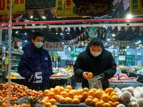 People wear face mask in a fruit shop in Beijing as the country is hit by an outbreak of the novel coronavirus, China, February 26, 2020.